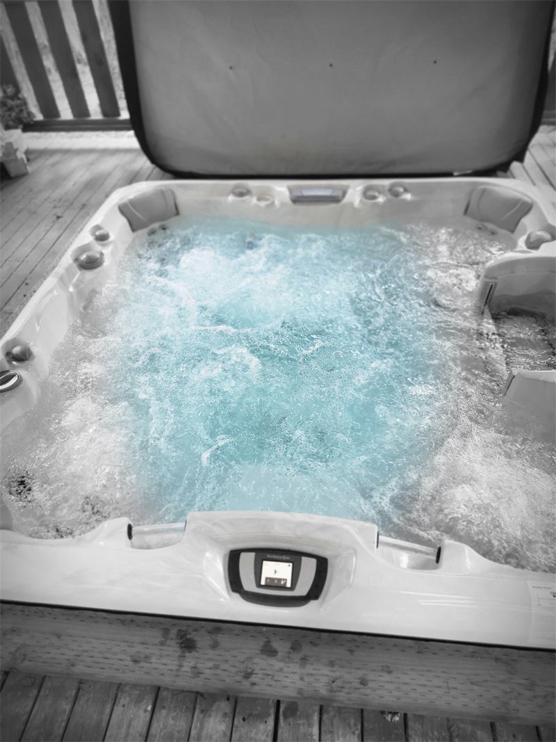 Close-up of a hot tub with clear turquoise water churning from the jets