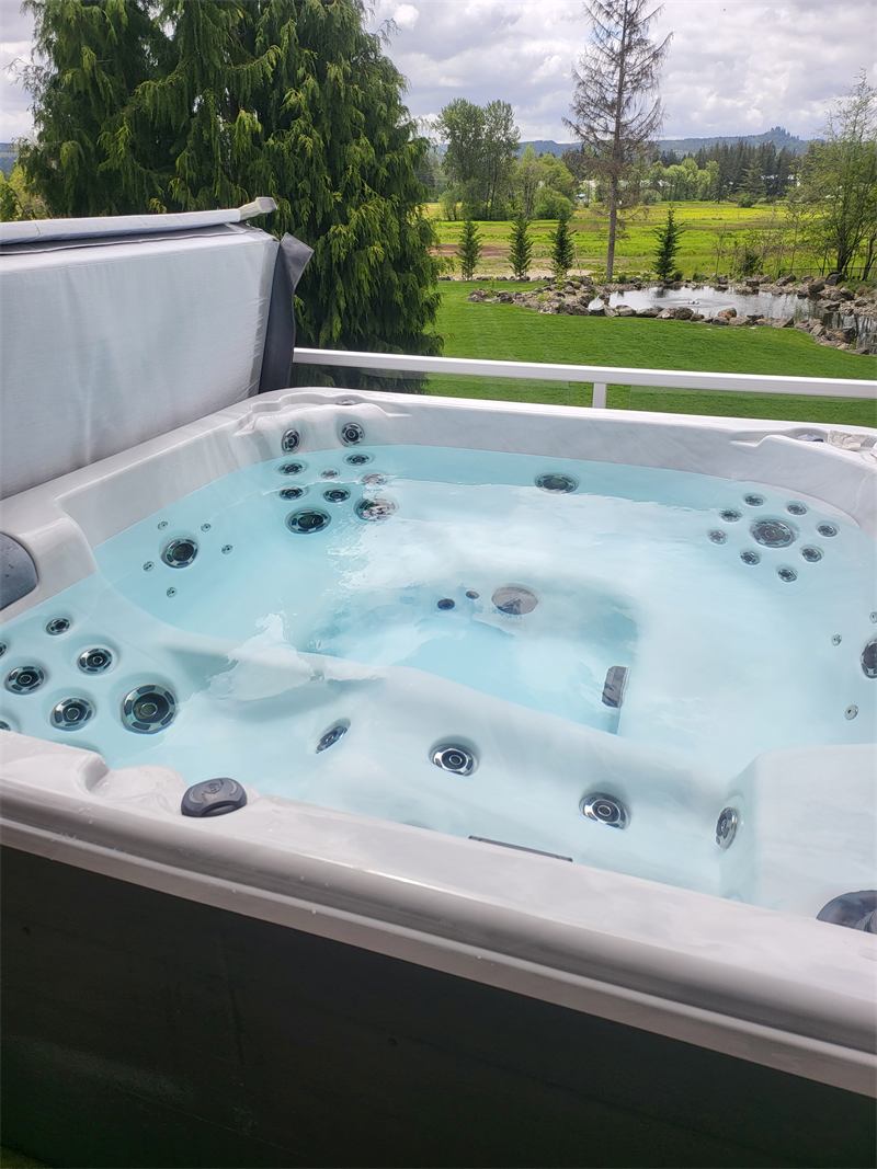 Freshly refilled hot tub overlooking a pond and distant mountains