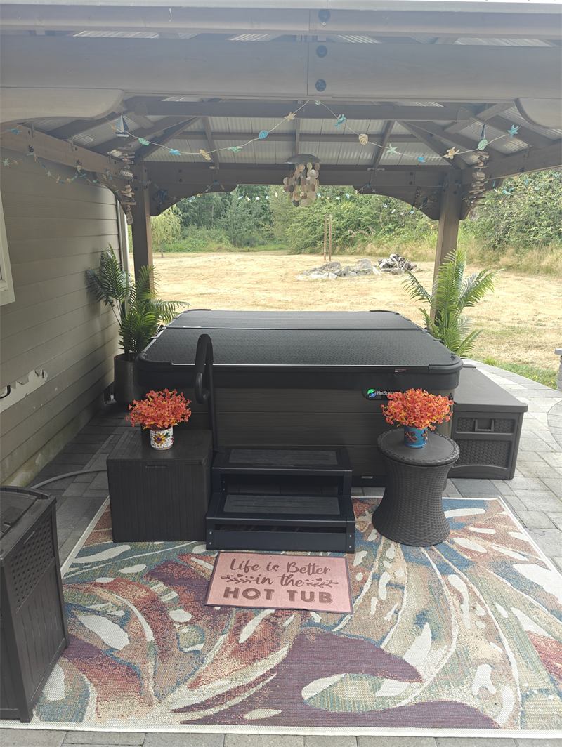 Covered hot tub under a backyard gazebo ready for the season
