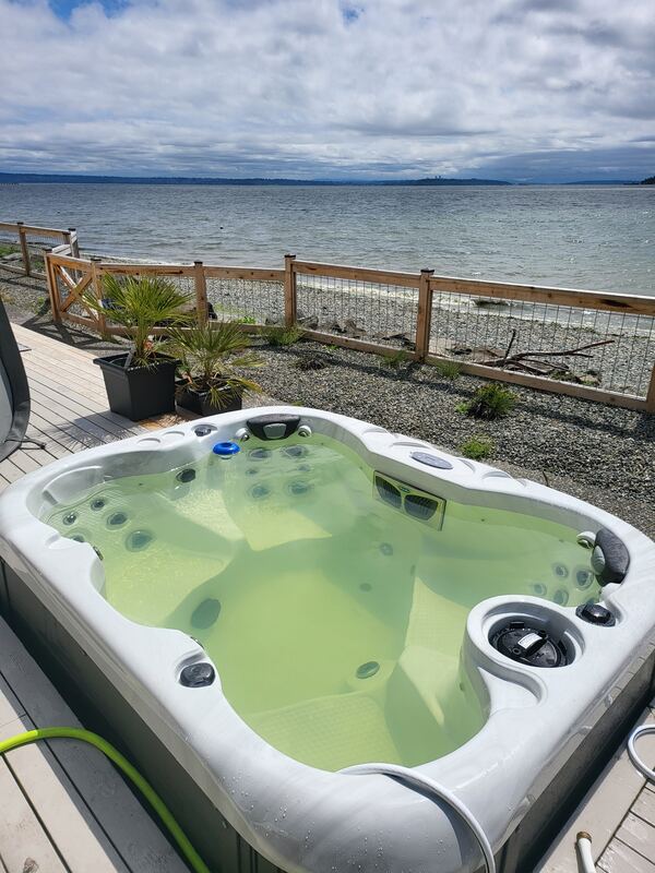 Pea-green hot tub water on a real oceanfront deck before recovery