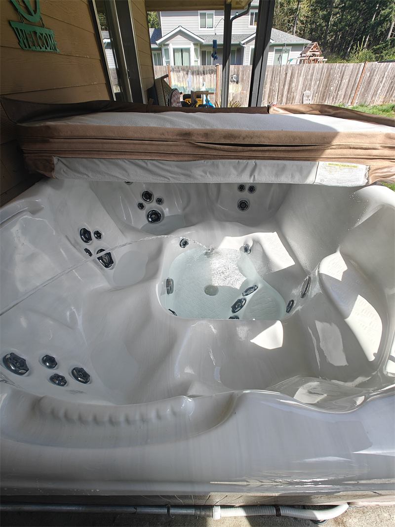 Hot tub with clear bubbling water under a covered patio awning