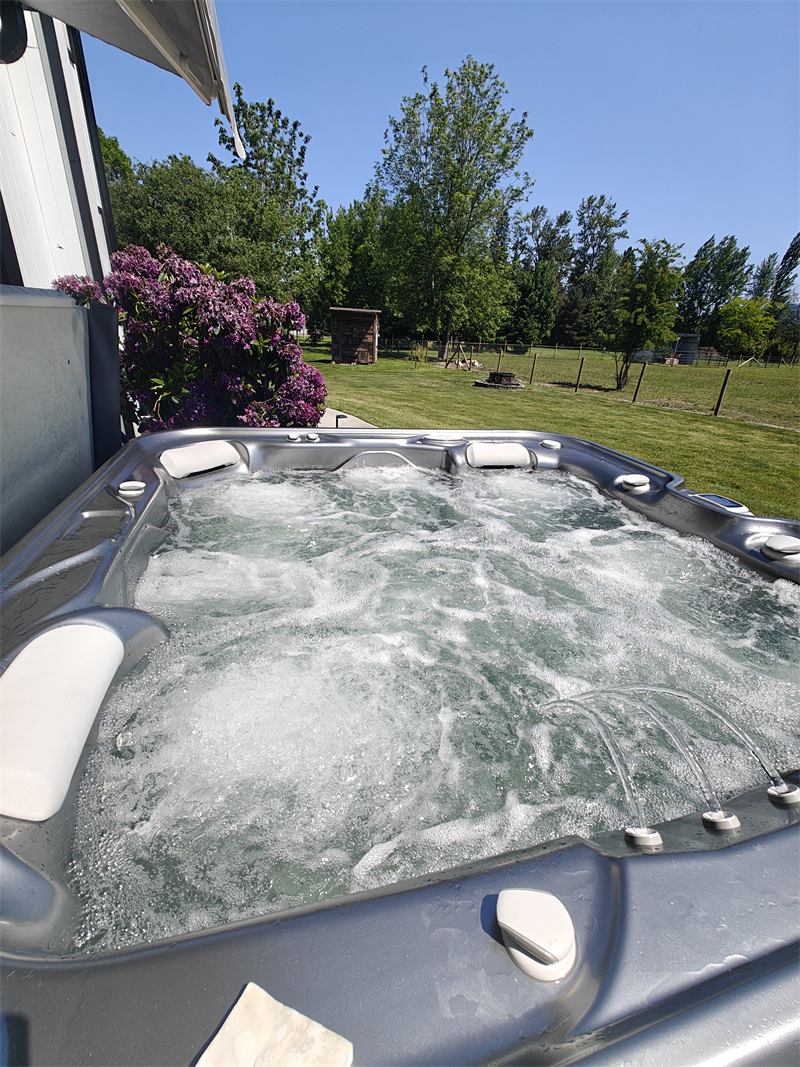 Clean hot tub beside a blooming rhododendron