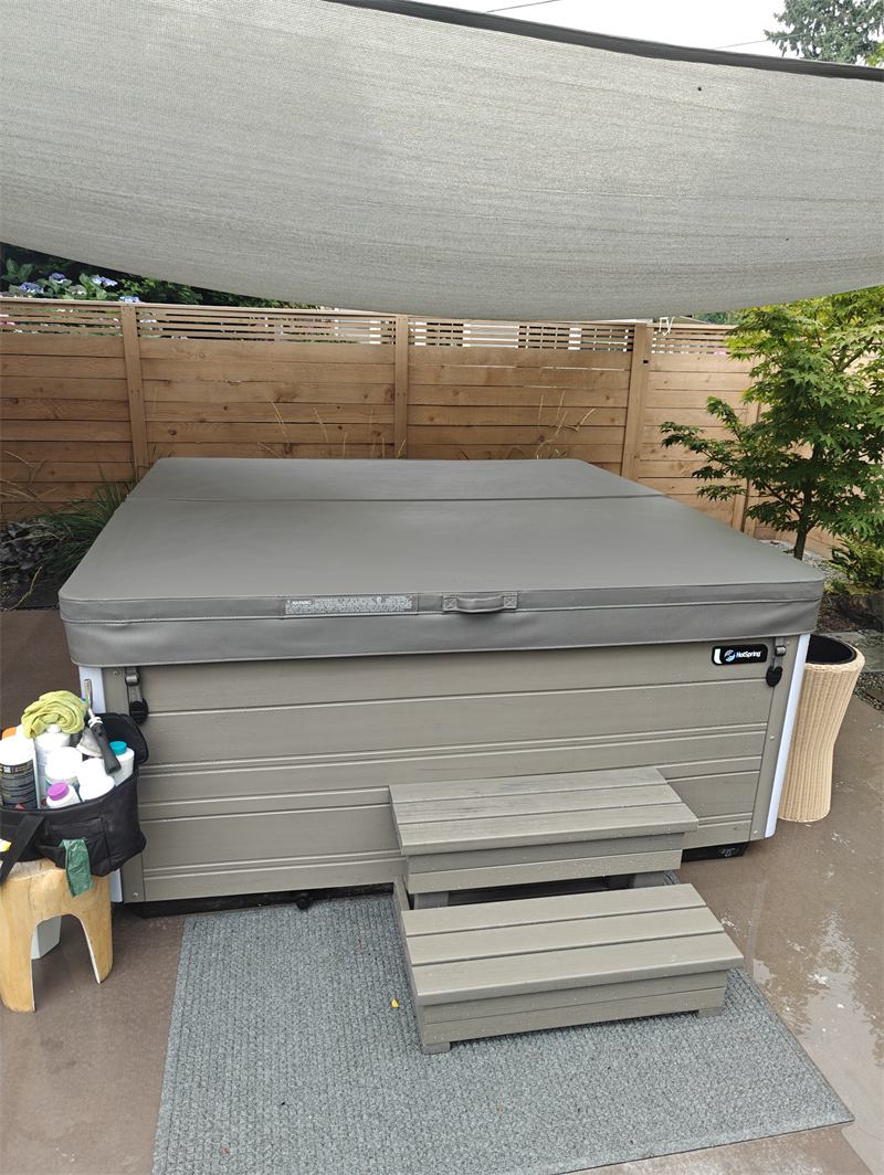Hot tub closed up after service with a tidy chemical caddy beside it