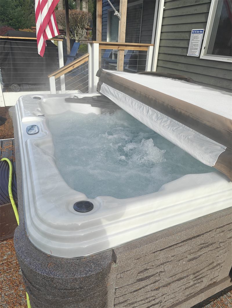 Same hot tub opened up with steaming clean water beside the lake